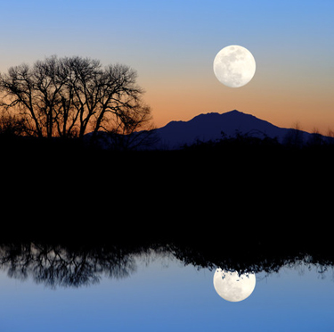 Moon at sunset reflecting in the water.
